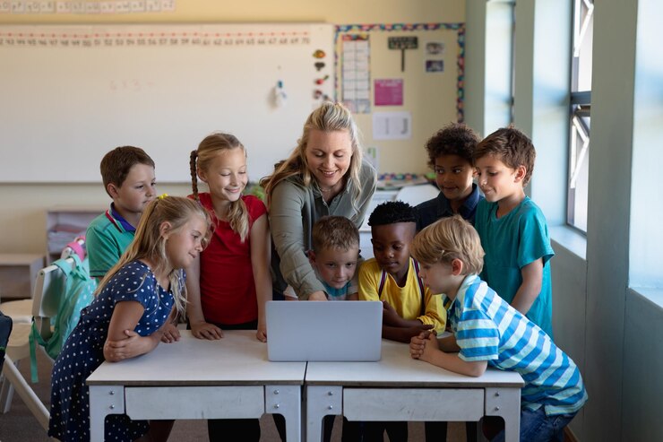 Foto lehrerin benutzt einen laptop mit einer gruppe von schulkindern