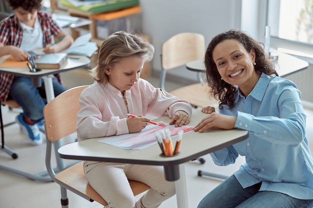 Lehrerin hilft Kindern im Grundschulunterricht