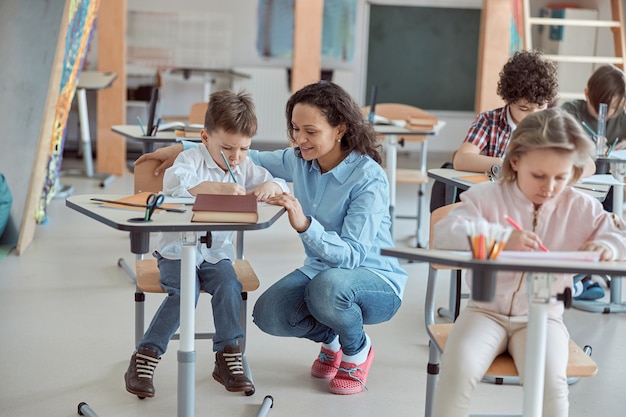 Lehrerin hilft Kindern im Grundschulunterricht