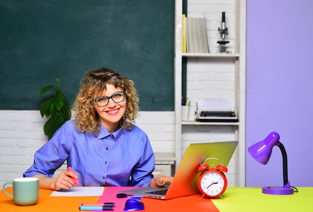 Lehrerin in der Nähe der Tafellehrerin, die sich auf die Hochschulprüfungen des Lehrertages vorbereitet