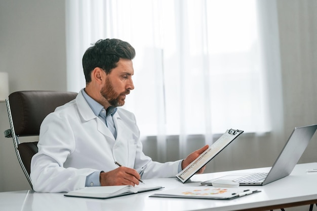 Leia o documento O médico em roupas formais está a trabalhar no gabinete
