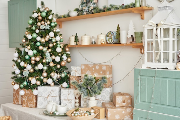 Leichte Innenküche mit Weihnachtsdekor und -baum. Türkisfarbene Küche im klassischen Stil.