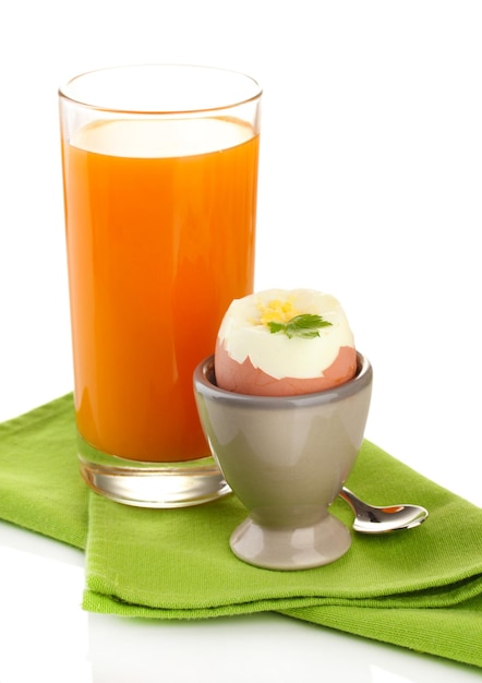 Leichtes Frühstück mit gekochtem Ei und Glas Saft, isoliert auf weiss