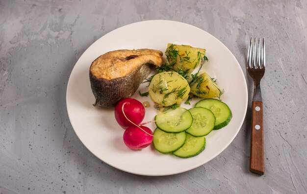 Leichtes Mittagessen mit Meerforellen, Kartoffeln, Gurken, Radieschen und Kräutern