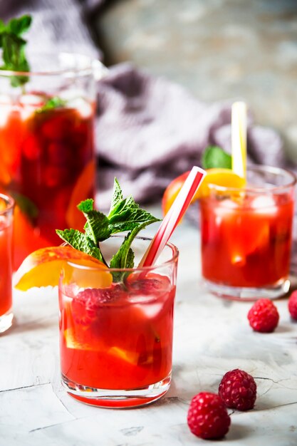 Leichtes Sommererfrischungsgetränk mit Früchten und Beeren - Sangria. In Gläsern auf einem grauen Tisch