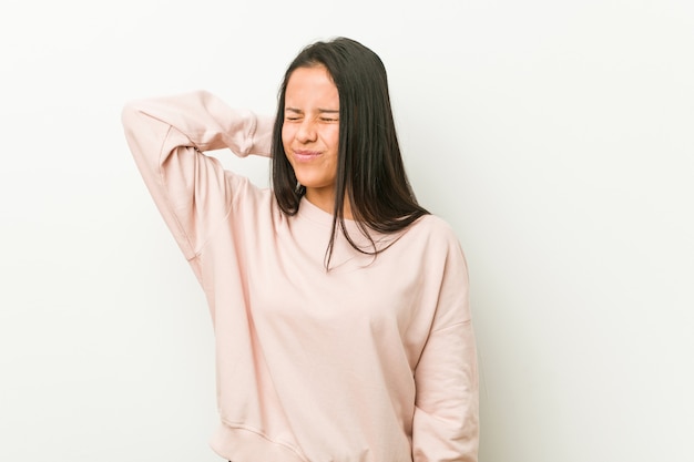 Leidende Nackenschmerzen der jungen netten hispanischen Jugendlichfrau wegen des sitzenden Lebensstils.