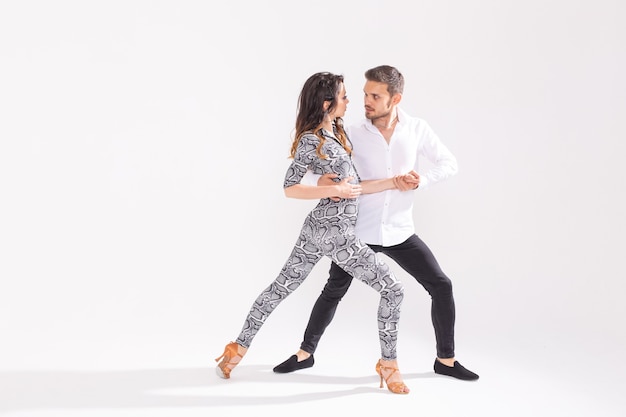 Leidenschaftliches Paar tanzt Social Danse Kizomba oder Bachata oder Semba oder Taraxia auf weißem Hintergrund mit Kopierraum