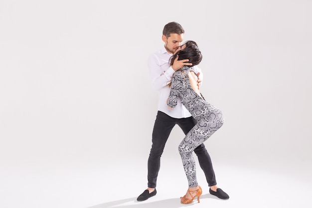 Leidenschaftliches Paar tanzt Social Danse Kizomba oder Bachata oder Semba oder Taraxia auf weißem Hintergrund mit Kopierraum