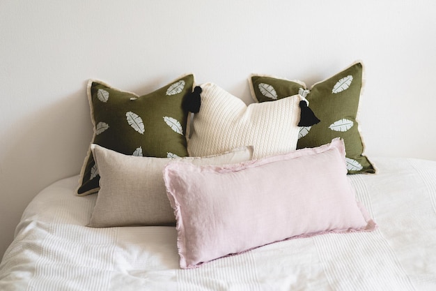 Leinenkissen auf einem weißen Bett Bequemes Bett mit Kissen im Zimmer Moderne Wohnkultur Innenarchitektur-Vorlage