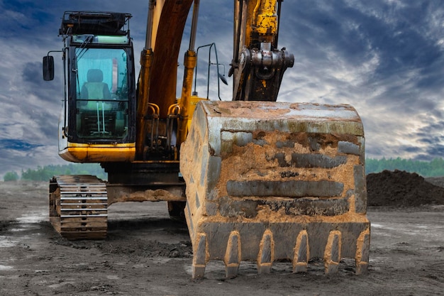 Leistungsstarke Bagger auf einer Baustelle gegen einen blauen bewölkten Himmel Erdbewegungsbaumaschinen Moderne Baumaschinen