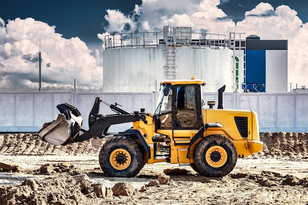 Leistungsstarker Bulldozer oder Lader bewegt die Erde auf der Baustelle gegen den Himmel Eine Erdbewegungsmaschine nivelliert die Baustelle Schwere Baumaschinen für Erdarbeiten