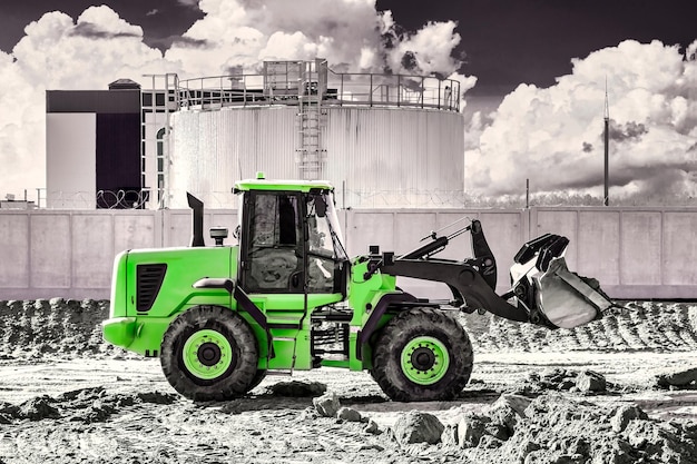 Leistungsstarker Bulldozer oder Lader bewegt die Erde auf der Baustelle gegen den Himmel Eine Erdbewegungsmaschine nivelliert die Baustelle Schwere Baumaschinen für Erdarbeiten