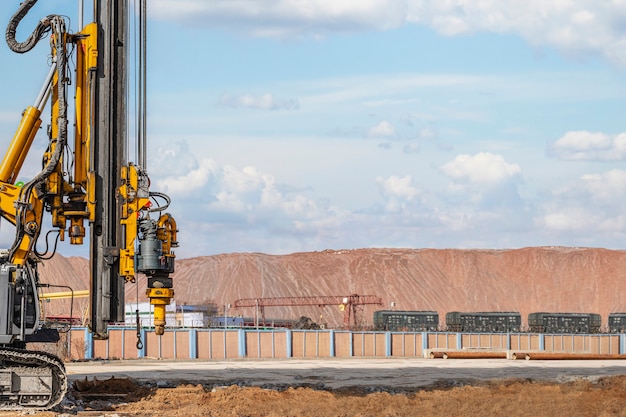 Leistungsstarkes hydraulisches Bohrgerät auf einer Baustelle. Einbau von Bohrpfählen durch Bohren. Pfahlgründungen. Bohren im Boden.