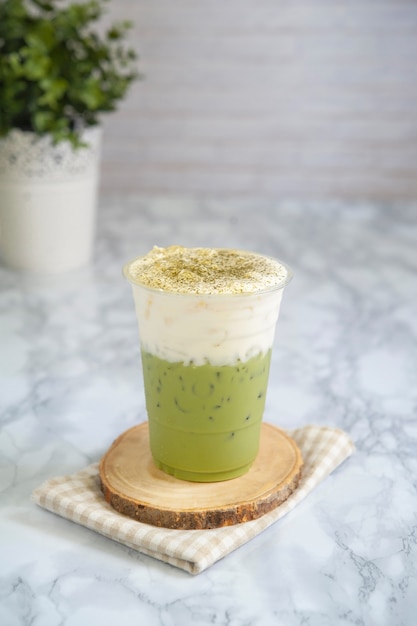 Leite chá verde em cima de cream cheese em vidro plástico.