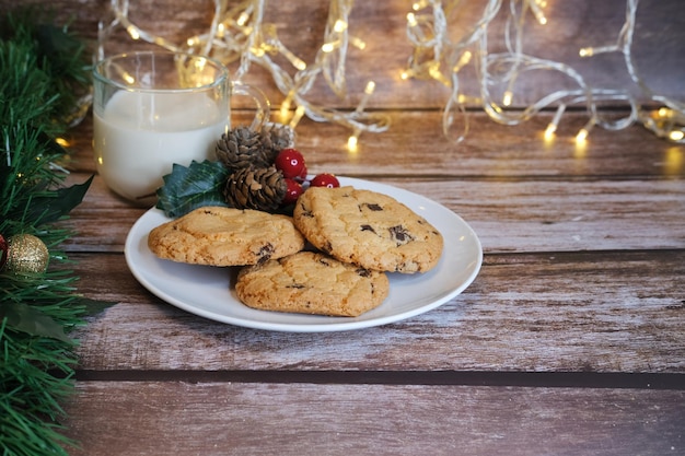 Leite com biscoitos de Natal para o Papai Noel em uma mesa de madeira, foco seletivo.