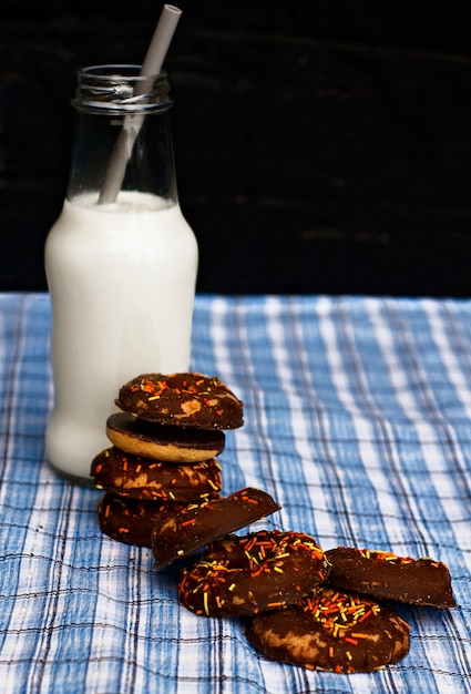 Leite com um cookie em uma garrafa de vidro em um fundo de madeira