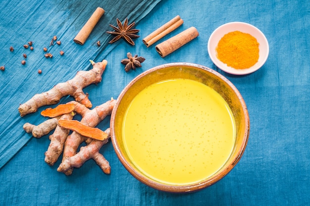 Foto leite de açafrão com ingredientes sobre fundo azul