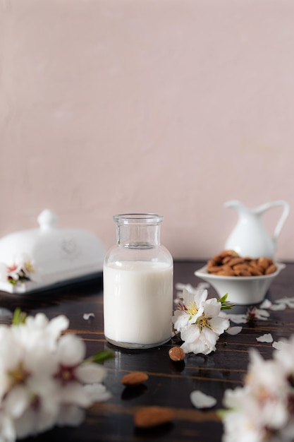 Leite de amêndoa com amêndooas e flores de amêndoas na mesa a alternativa vegana ao leite tradicional