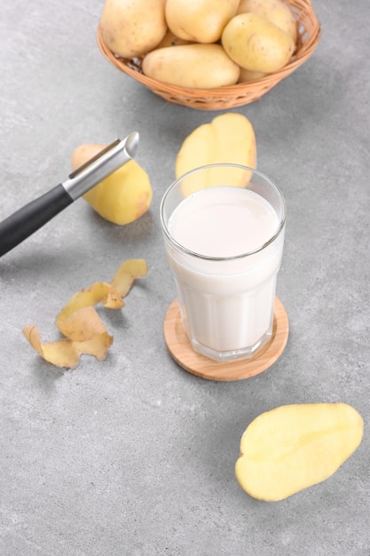 Leite de batata vegano e batata no fundo da mesa de pedra cinza Substituto de leite alternativo à base de plantas e sem lactose