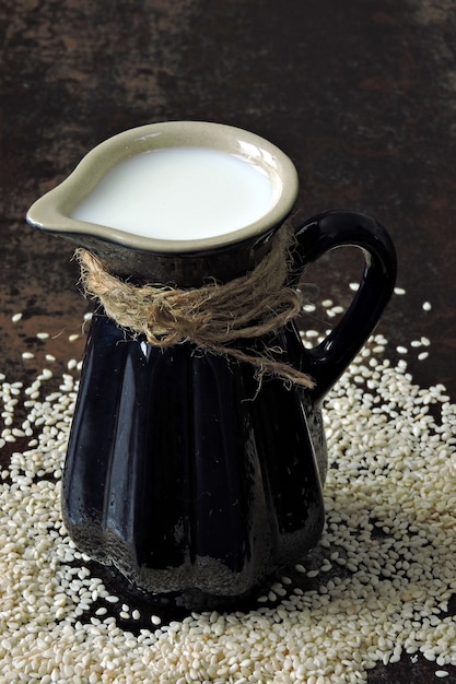 Leite de gergelim em uma jarra. bebidas veganas.