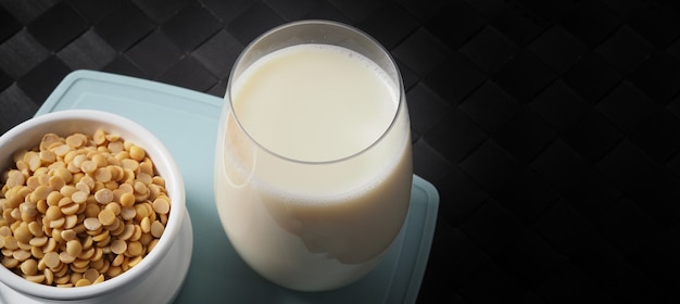 leite de soja sem açúcar adicionado em um copo em uma placa de plástico verde imagens de close
