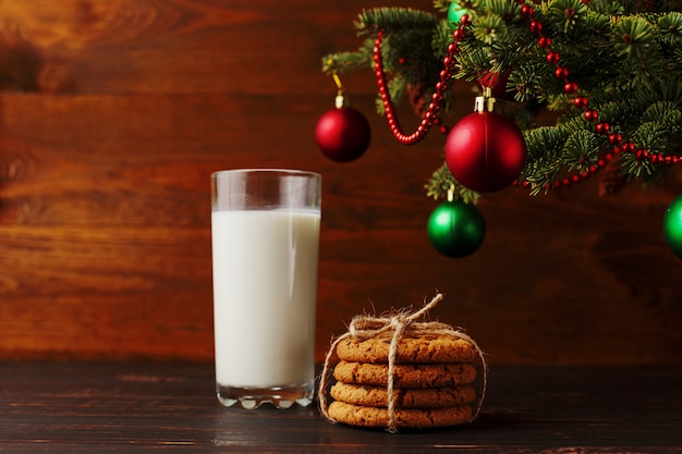 Leite e biscoitos para o Papai Noel debaixo da árvore de Natal. copyspace