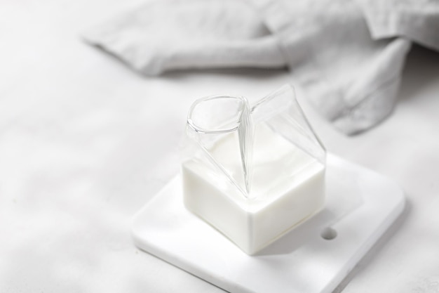 Leite em frasco de vidro com guardanapo Leite no moderno jarro de leite Sunshine Marble board fundo cinza