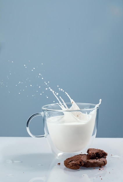 Foto leite em uma caneca de vidro com biscoitos