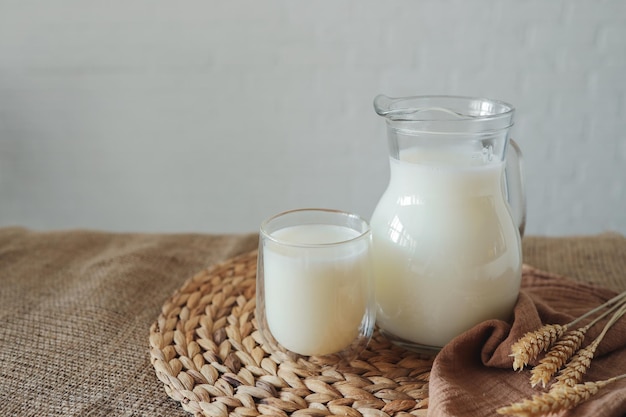 Leite natural fresco em um copo e jarro em casa