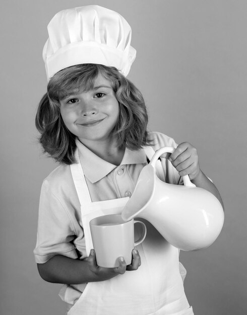 Foto leite para crianças cozinhando crianças chef menino fazendo legumes frescos para comer saudável retrato de