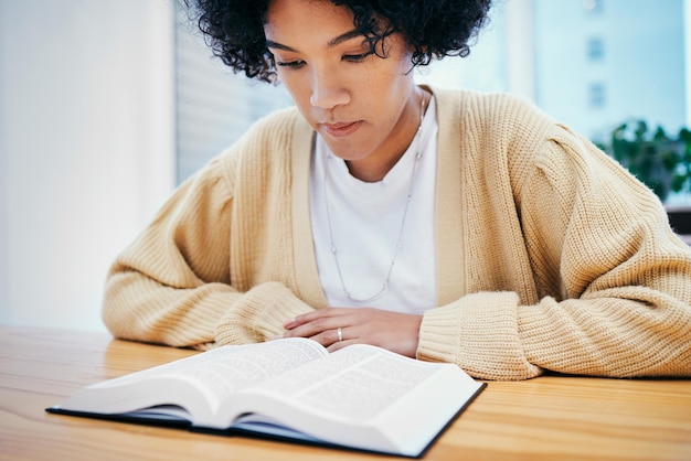 leitura da Bíblia e mulher estudando religião na mesa em casa fé cristã e conhecimento de Deus louvor aprendizado e menina na mesa com livro sagrado evangelho e inspiração para oração no apartamento