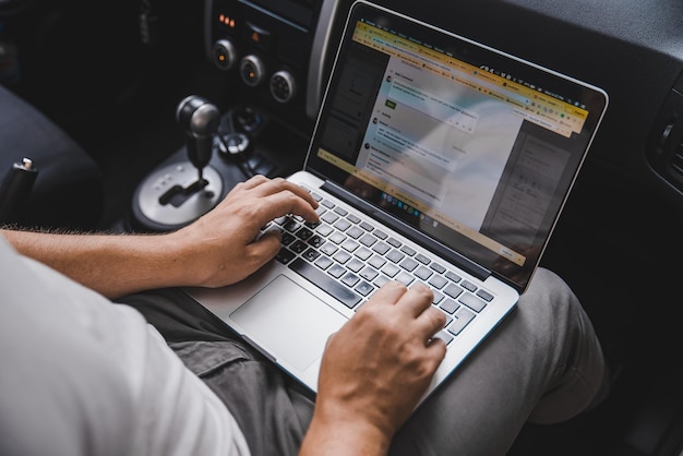 Lemberg, ukraine, 22. august 2018, junger erwachsener mann, der im auto am laptop arbeitet