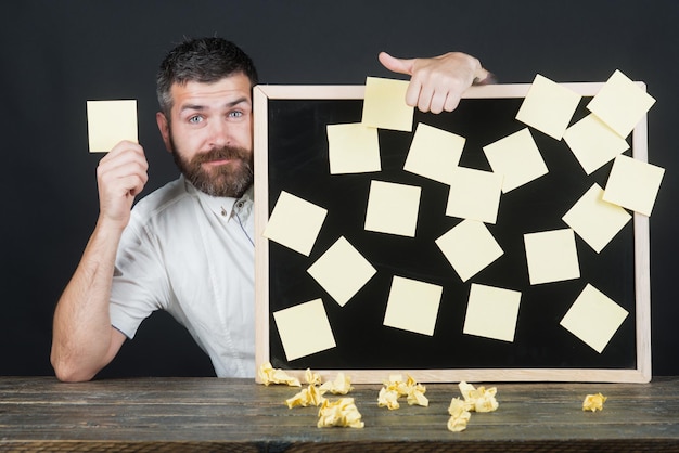 Lembrete de anotações de adesivos planejando gestão de empregos e conceito de pessoas Homem barbudo feliz sentado