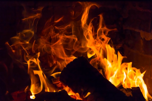 La leña arde con un fuego naranja en la chimenea Calefacción de la casa sin electricidad