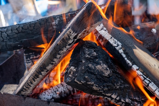 La leña se quema en la parrilla.