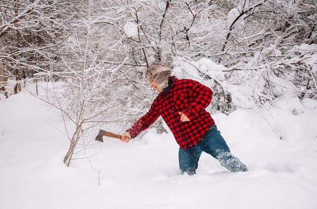 Leñador en invierno bosque nevado hipster con hacha leñador estilo de vida guapo trabajando en el bosque