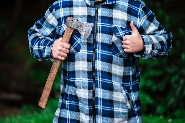 Un leñador trabaja en el bosque Leñador con un hacha en el bosque de verano El leñador sostiene un hacha El leñador sostiene un hacha en su espalda El leñador muestra la clase Hacha en mano