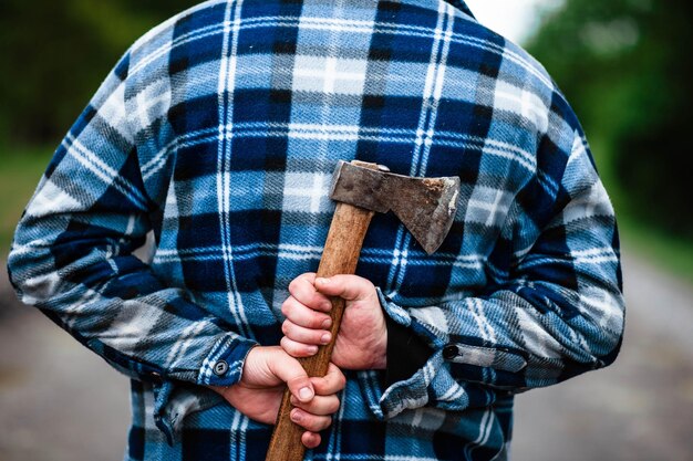 Un leñador trabaja en el bosque Leñador con un hacha en el bosque de verano El leñador sostiene un hacha El leñador sostiene un hacha en su espalda El leñador muestra la clase Hacha en mano