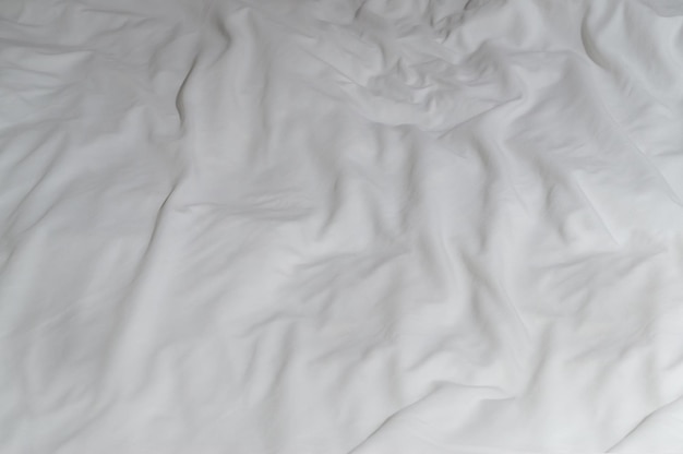 Lençol ou cobertor branco amassado ou enrugado com padrão após o uso do hóspede, tirado no quarto do hotel resort com espaço para cópia Textura de fundo do cobertor desarrumado