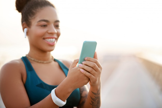 Lendo mensagem. Moreno mulher sorrindo enquanto lê a mensagem do namorado após treino