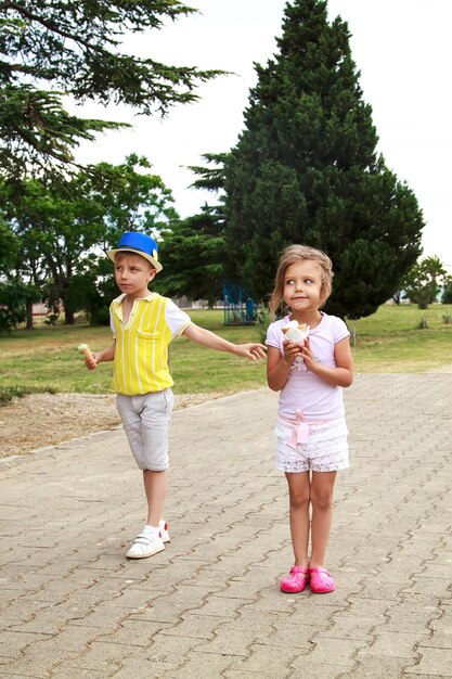 Lengua completa de hermano y hermana de pie en el parque