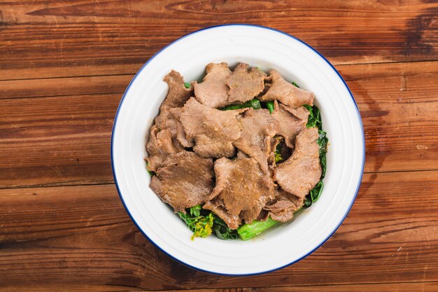 Lengua de ternera hervida con verduras se sirve en un plato en un restaurante.