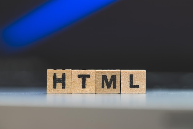 Lenguaje web HTML Cubos de madera con letras HTML sobre un concepto de computadora portátil para HTML