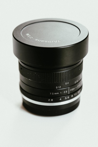 Una lente de la cámara en una superficie blanca Foto de stock