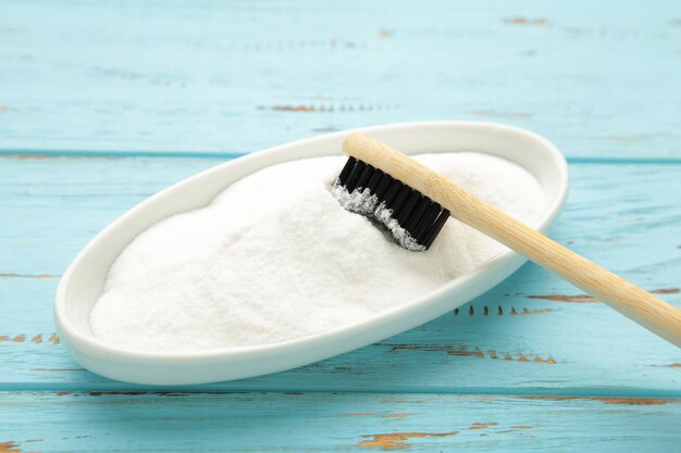 Lente de dientes y bicarbonato de sodio para limpiar sobre un fondo azul