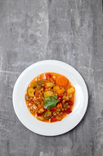 Lentejas con pimiento, calabacín y cebolla en manjar blanco sobre cerámica