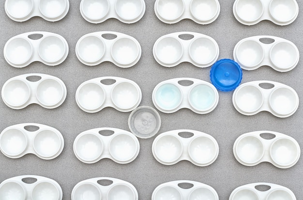 Lentes en un recipiente sobre un fondo gris. un patrón de envases para lentes