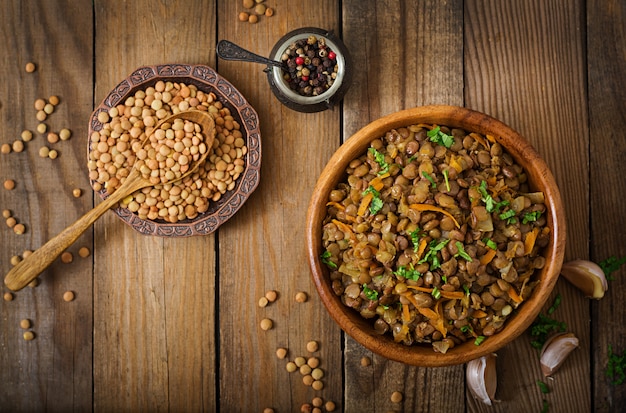 Lentilha com cenoura e cebola em uma tigela de madeira