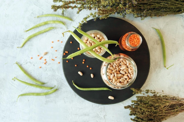 Lentilhas de grão de bico de feijão e ervas secas na mesa de cozinha produtos naturais orgânicos