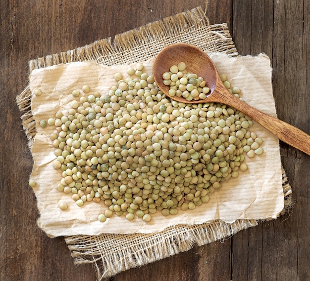 Lentilhas verdes com uma colher em uma mesa de madeira